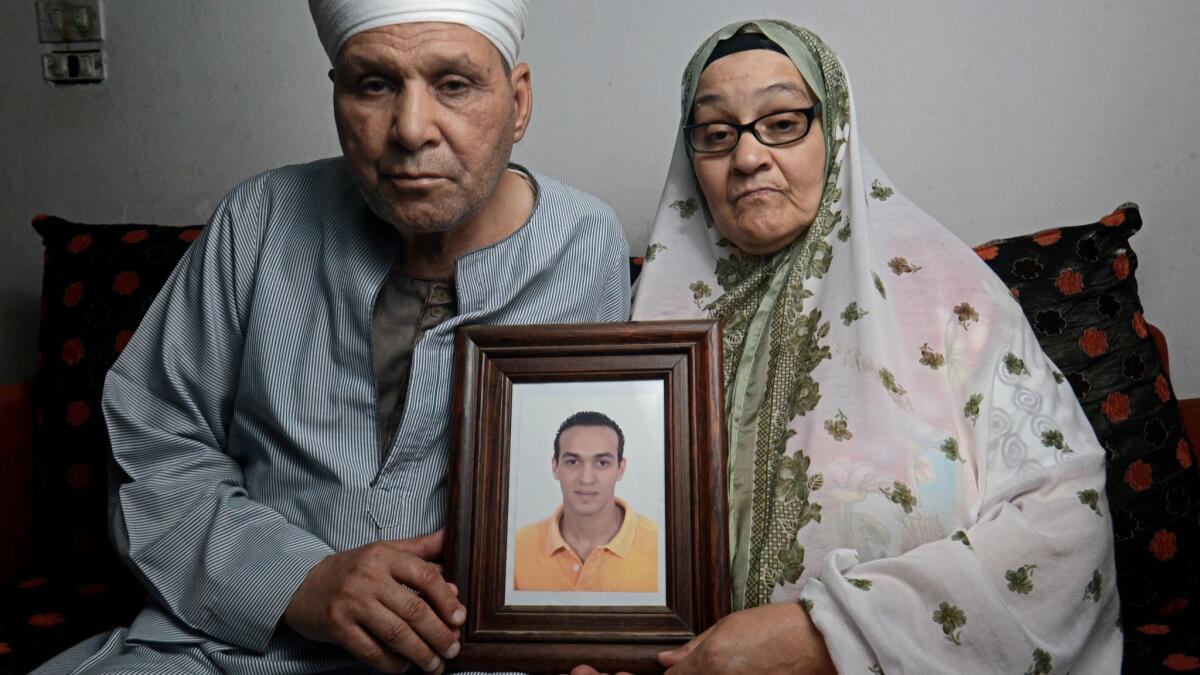 Abdel Shakour Abou Zeid and his wife hold a photo of their son Mahmoud Abou Zeid, a photojournalist imprisoned since he was arrested in 2013 while covering a police crackdown on protesters.