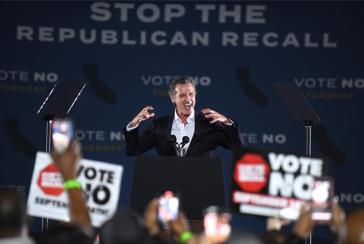 Gov. Gavin Newsom cheers with the crowd at a rally