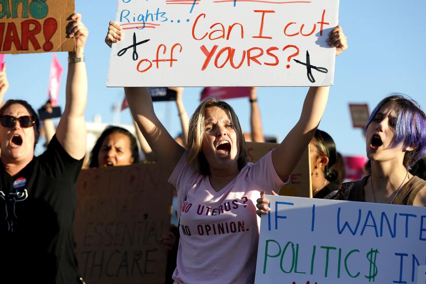 Caroline Field joins demonstraters as she protests the decision by the Supreme Court to overturn the Roe vs. Wade ruling during a Planned Parenthood protest at Main Beach in Laguna Beach on Friday.