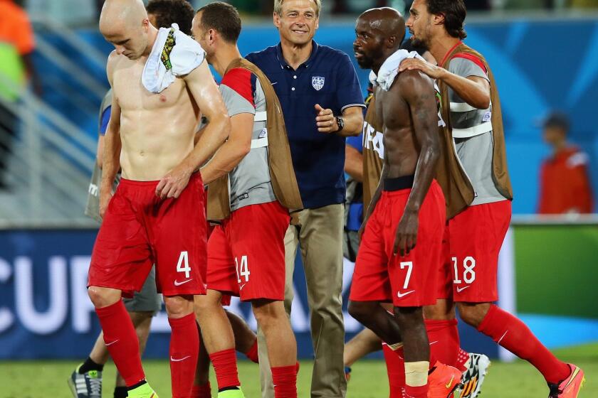 U.S. Coach Juergen Klinsmann, center, is smiling after his players' 2-1 victory over Ghana in a World Cup opening match.