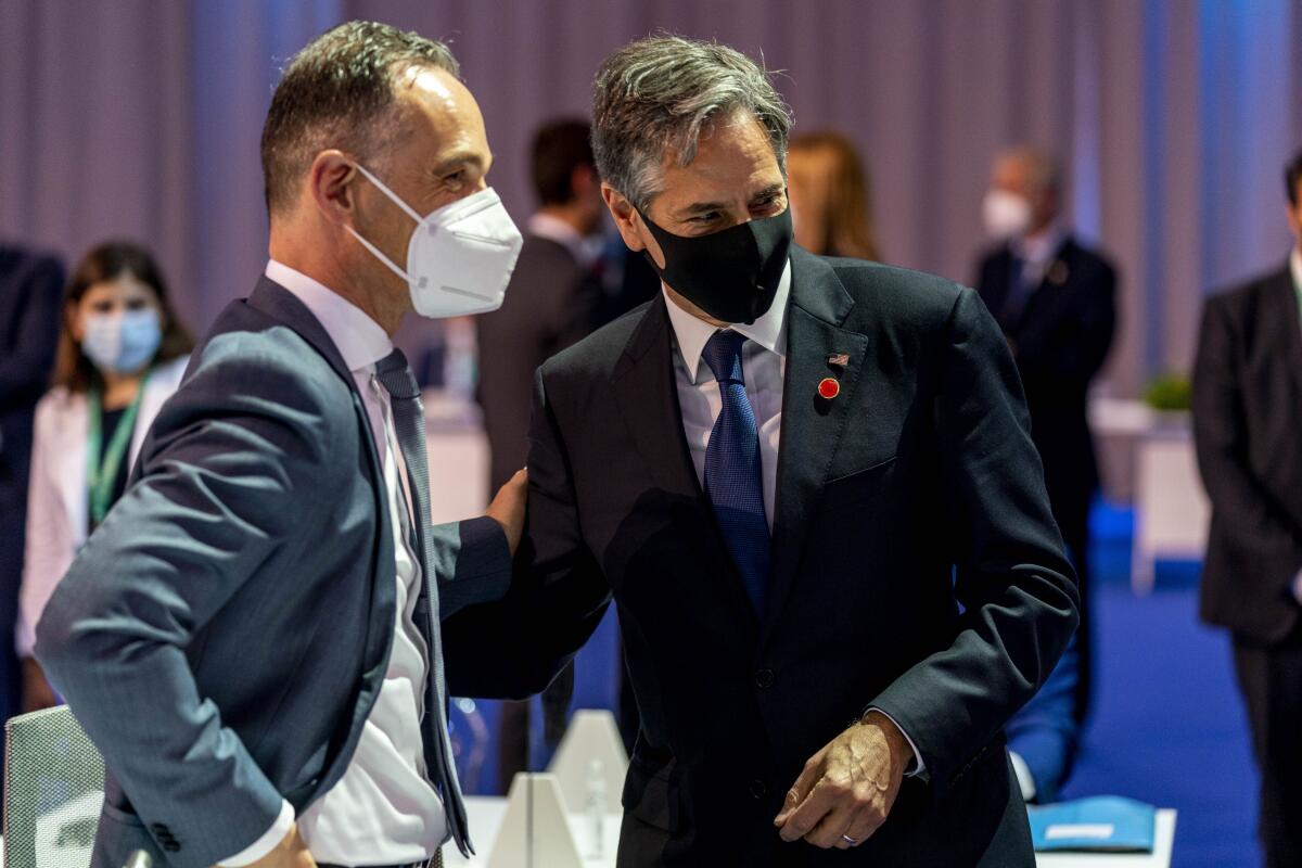 Heiko Maas and Antony Blinken, wearing masks, share a conversation