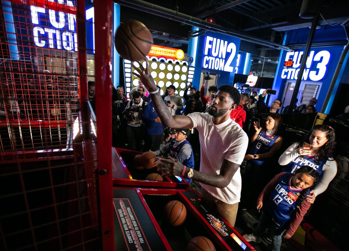 Clippers star Paul George shoots hoops with kids attending his third annual Christmas celebration at Dave & Buster's.