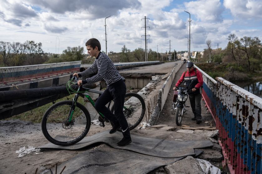 KUPIANSK, UKRAINE - OCTOBER 13: People cross the Oskil River on the remains of a bridge seriously damaged by fighting between Ukrainian and Russian occupying forces, on October 13, 2022 in Kupiansk, Kharkiv oblast, Ukraine. Josep Borrell, the EU's foreign policy chief, has warned Vladimir Putin that Russia's army would be "annihilated" by the West's military response if he uses nuclear weapons against Ukraine. (Photo by Carl Court/Getty Images)