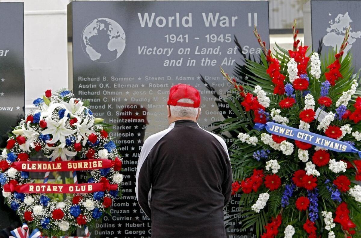 Cal Drake, 83, of Glendale, stops to look for his father's name at the World War II Memorial at City Hall in Glendale on Monday. His father, Hubert Drake, was killed while fighting in World War II.