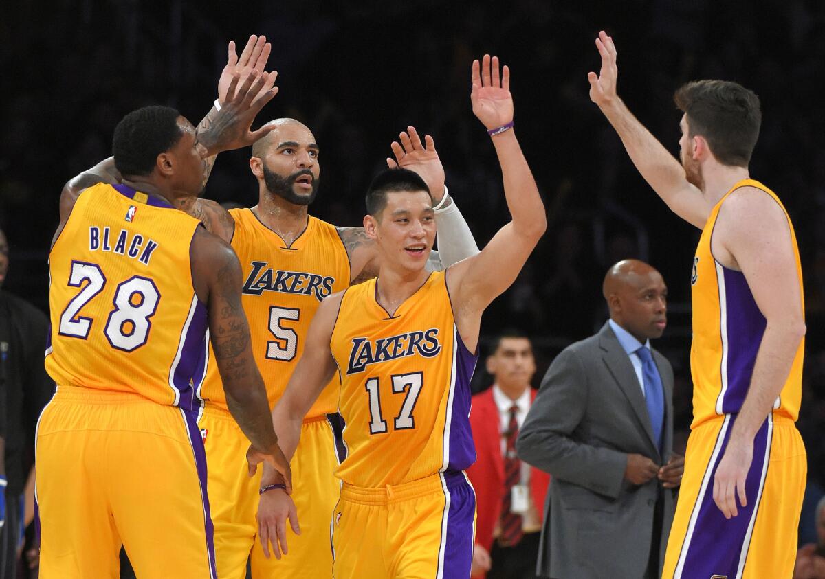 Los Angeles Lakers players Tarik Black (#28), Carlos Boozer (#5), Jeremy Lin (#17) and Ryan Kelly celebrate the victory over the Orlando Magic.