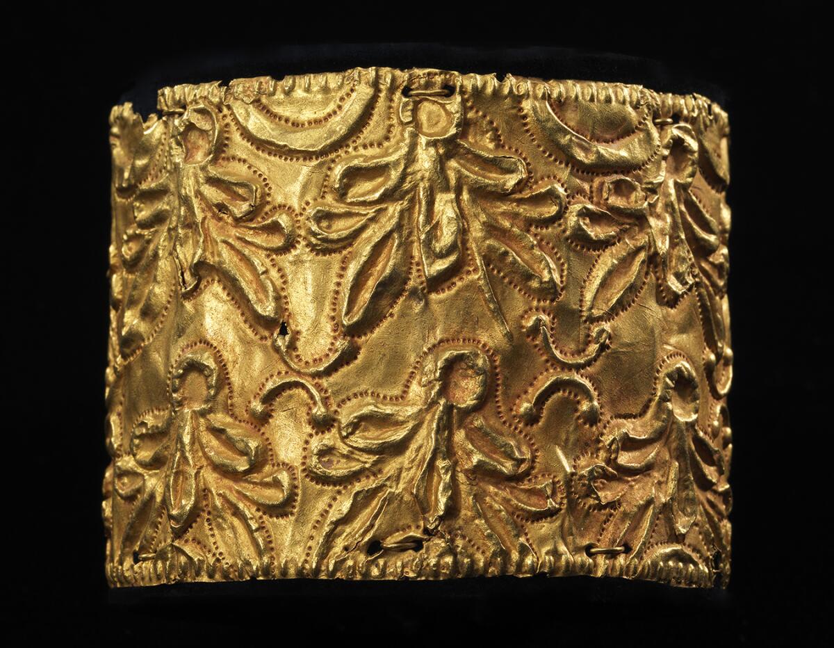 Lavish patterns suggesting banyan leaves adorn a gold decoration.