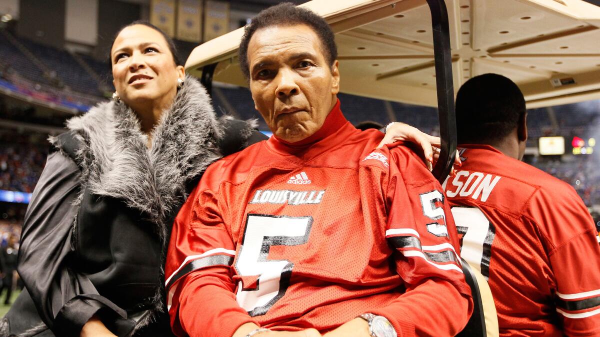 Muhammad Ali rides a golf cart with wife Lonnie before taking part in the coin toss at the start of the Sugar Bowl on Jan. 2, 2013, at the Superdome in New Orleans.