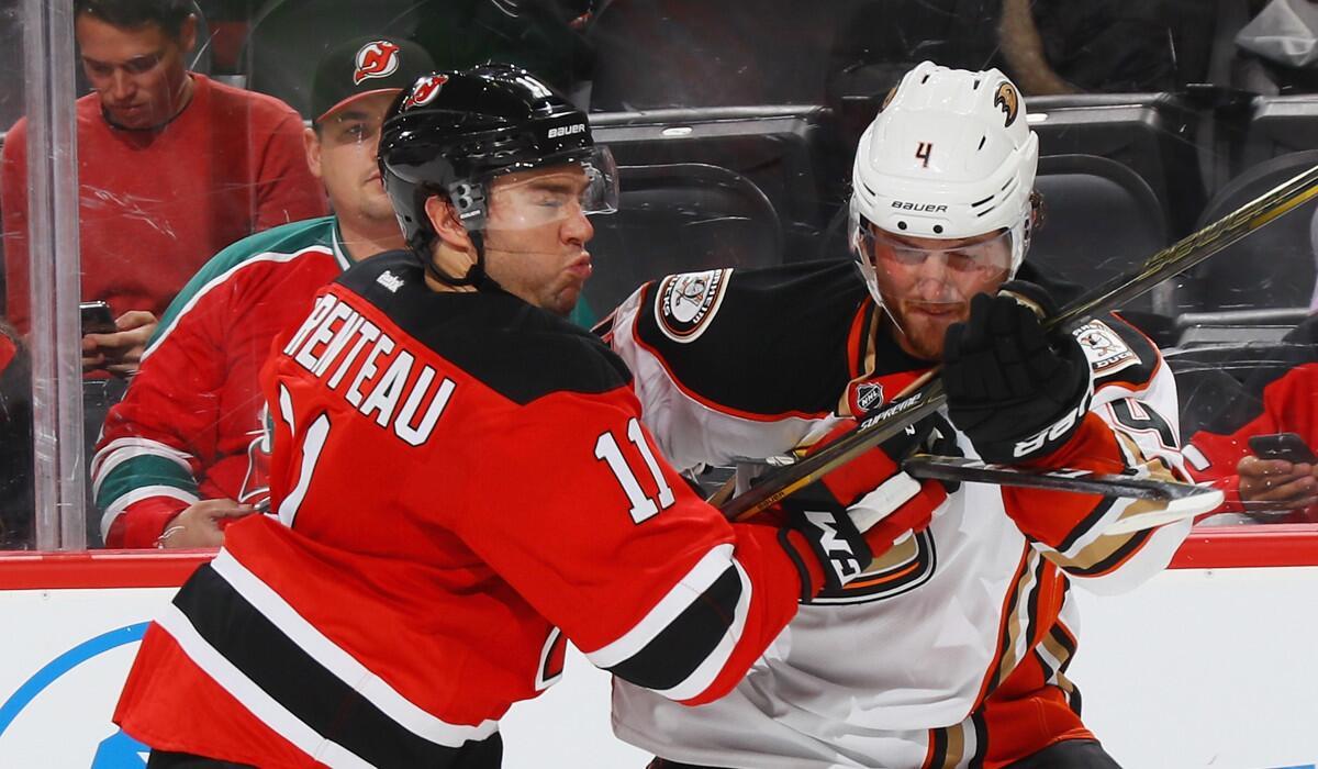 New Jersey Devils' PA Parenteau, left, holds back Ducks' Cam Fowler during the second period Tuesday.