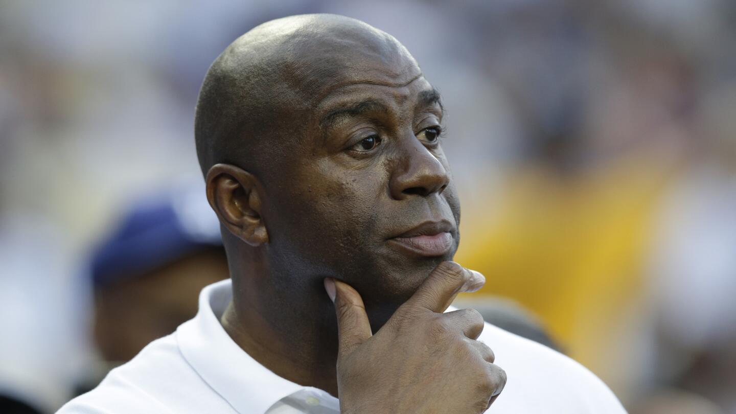 Lakers great and Dodgers co-owner Magic Johnson watches a game between the Dodgers and Cincinnati Reds at Dodger Stadium on May 27, 2014.
