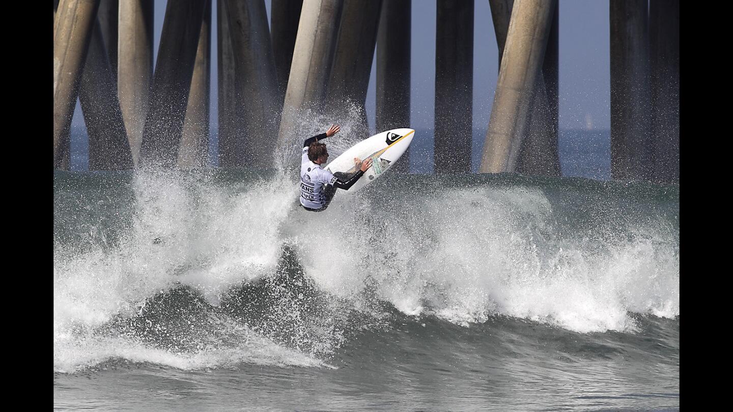 Huntington Beach's own Griffin Foy goes high up off the lip of a head-high wave during opening round of the Vans US Open of Surfing Pro Junior in Huntington Beach on Saturday. Foy took second in the heat to advance.