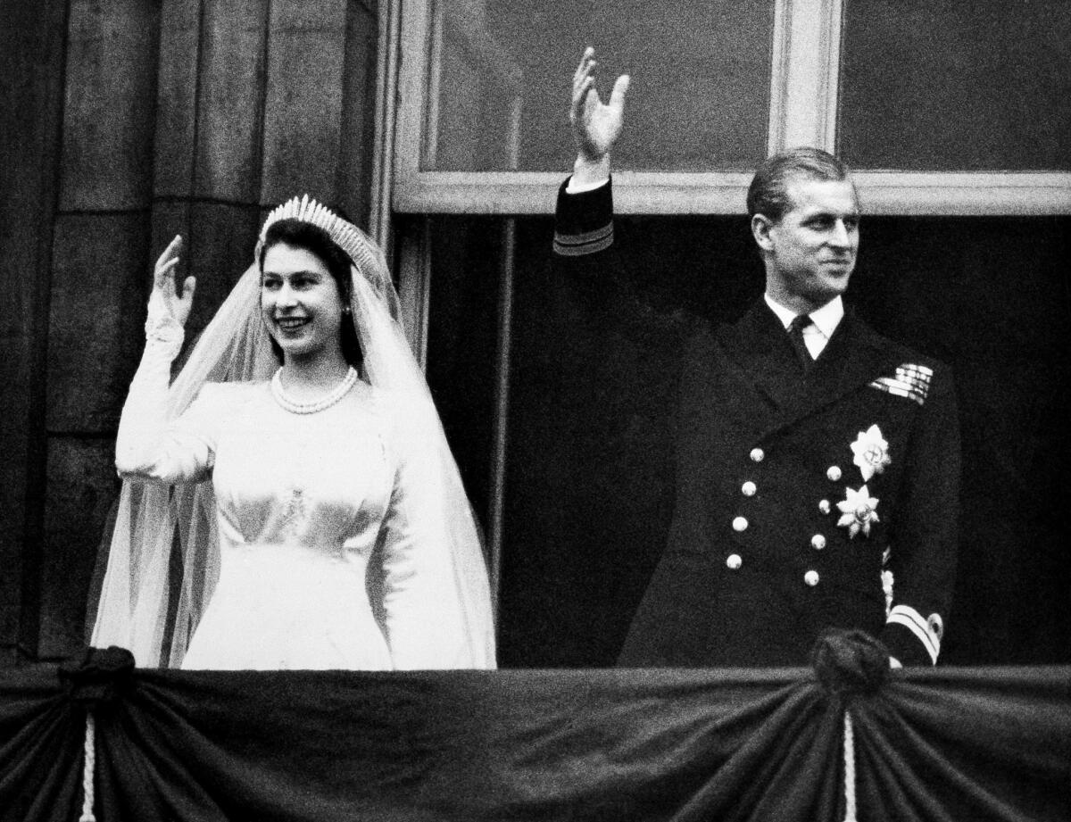 20 de noviembre de 1947: La princesa Elizabeth y el príncipe Philip, duque de Edimburgo, saludan desde el balcón del palacio de Buckingham después de su boda.