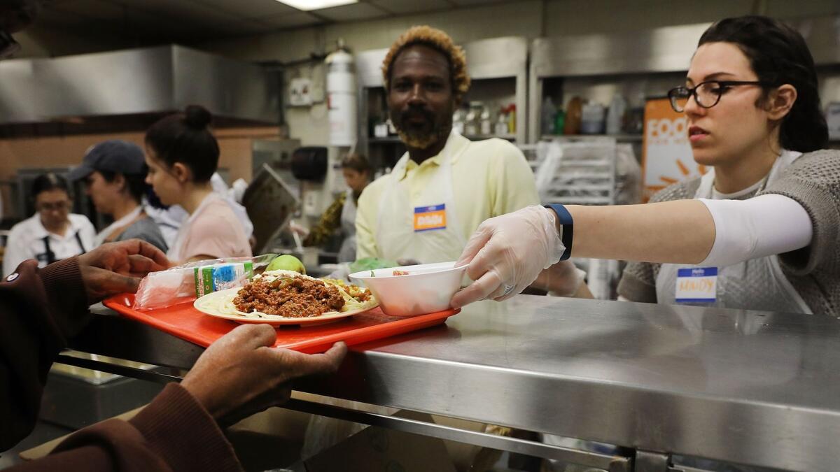 Volunteers serve an evening meal at the Food Bank for New York City community kitchen on May 15, 2017.