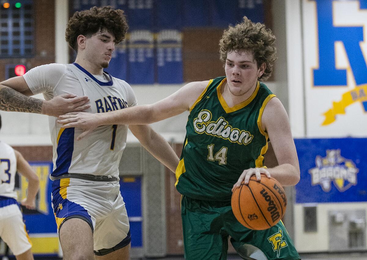 Edison's Dane Johnson drives the lane against Fountain Valley's Fernando Garcia during a Surf League game on Thursday.