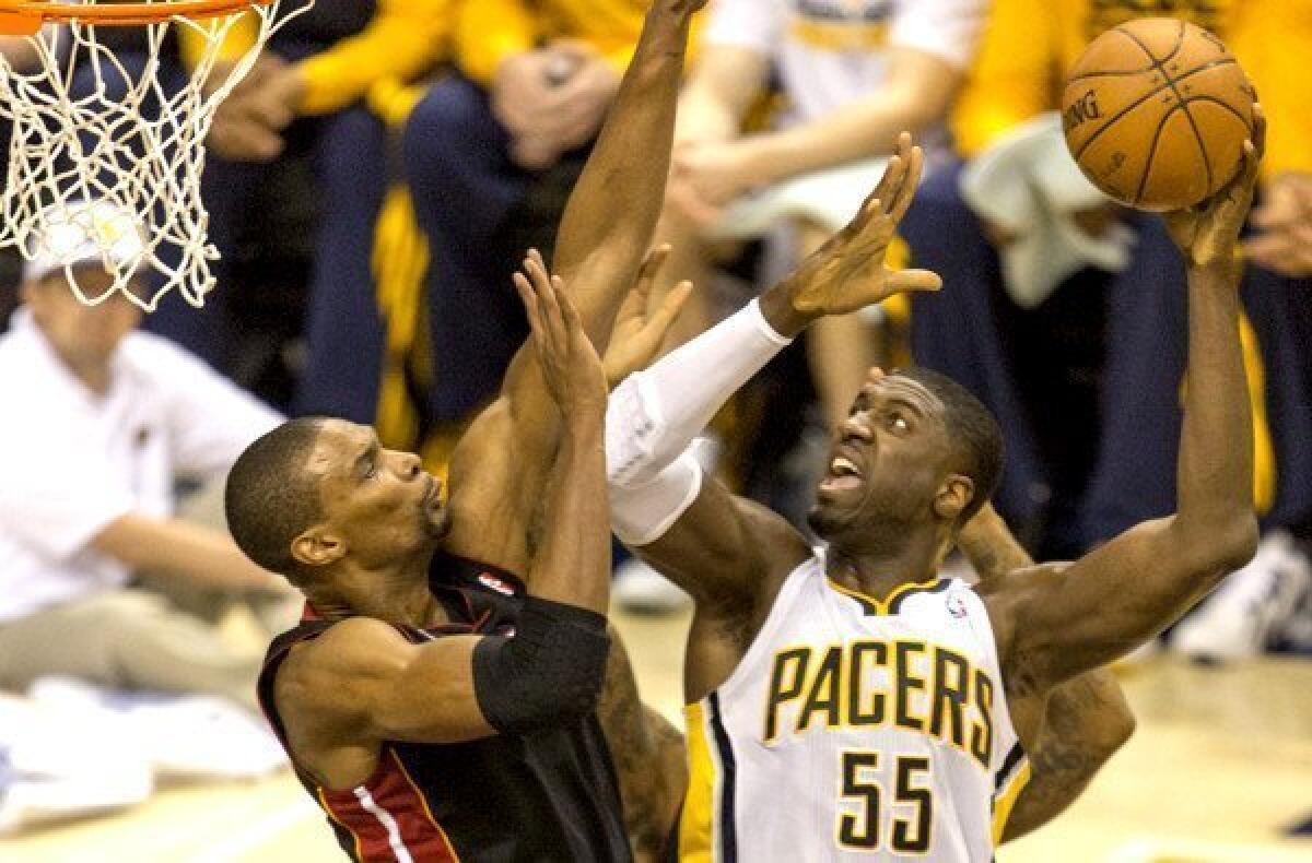 Pacers center Roy Hibbert powers his way to the basket against Heat power forward Chris Bosh during a playoff game last spring.