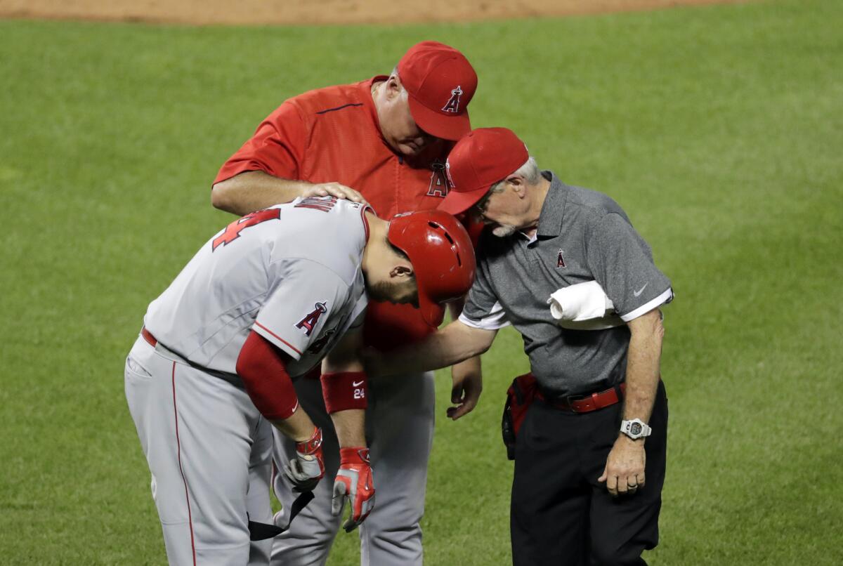 Los Angeles Angels' C.J. Cron, left, is tended to after being hit by a pitch in the sixth inning of a baseball game against the Baltimore Orioles in Baltimore, Friday, July 8, 2016. Cron left the game with a fractured bone in his left hand.(AP Photo/Patrick Semansky)