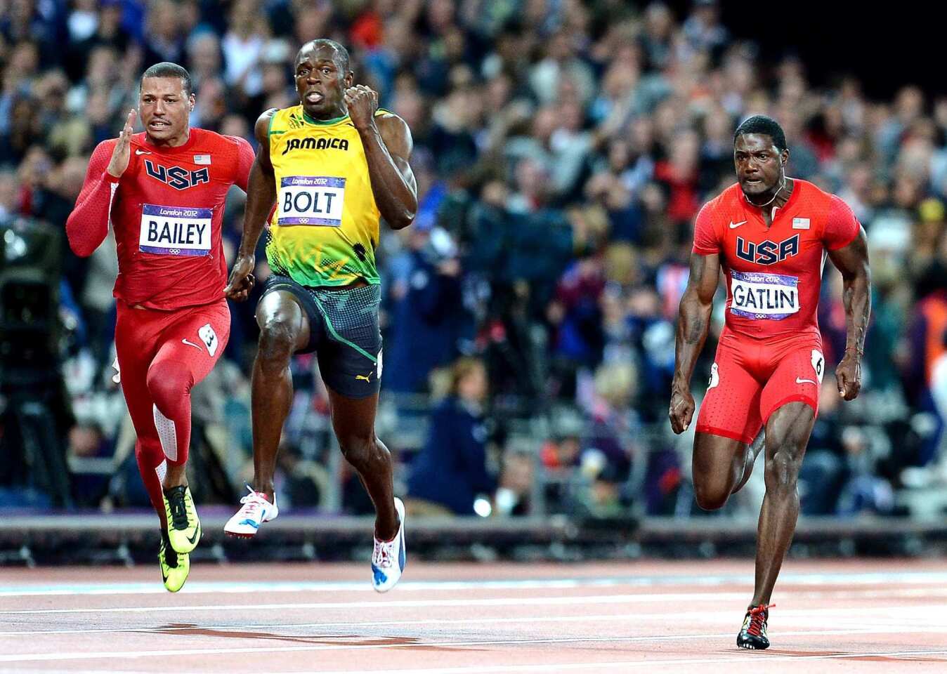 Jamaica's Usain Bolt pulls ahead of Team USA's Ryan Bailey, left, and Justin Gatlin to win gold in the 100 meters.