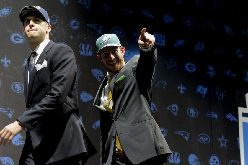 Jared Goff, left, after being selected by Los Angeles Rams as their number one overall pick and Carson Wentz, after being selected by the Philadelphia Eagles as their top pick in the first round of the 2016 NFL football draft greet fans at Selection Square in Grant Park, Thursday, April 28, 2016, in Chicago. (AP Photo/Matt Marton) ORG XMIT: ILMM113