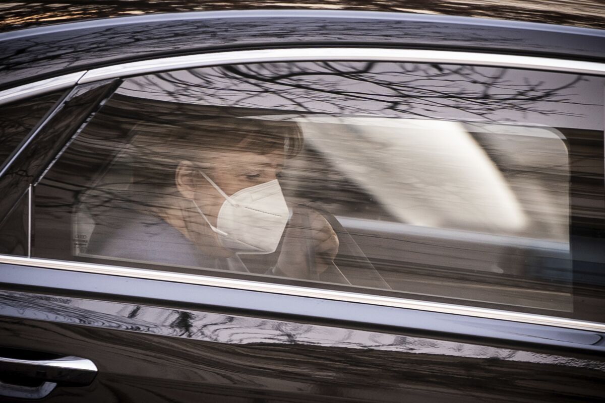 German Chancellor Angela Merkel (CDU), arrives in a car at the parliament for the beginning of the budget week in Berlin, Germany, Tuesday, Dec. 8, 2020. (Michael Kappeler/dpa via AP)