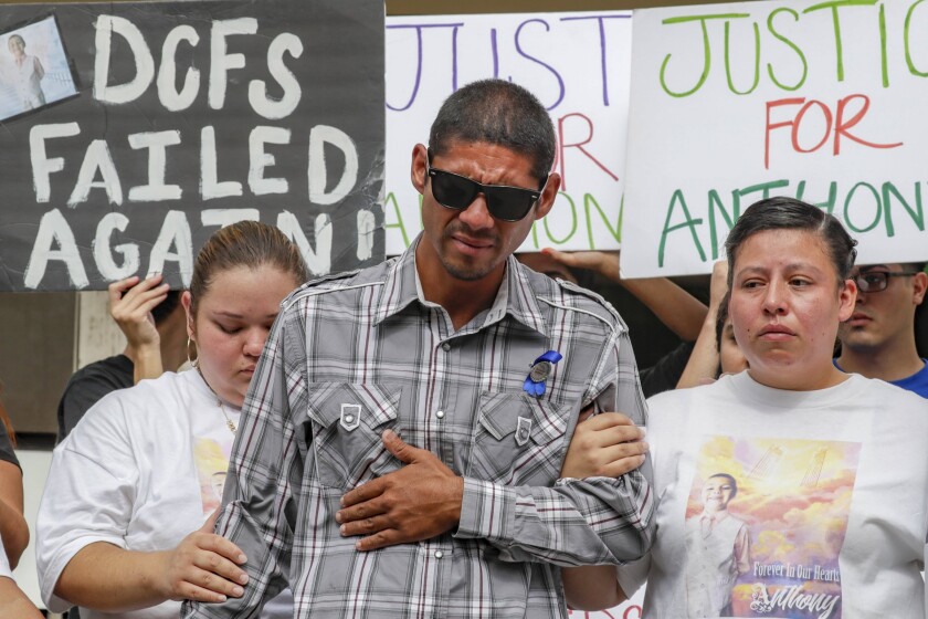 Victor Avalos, the father of Anthony Avalos, is comforted by two other people.