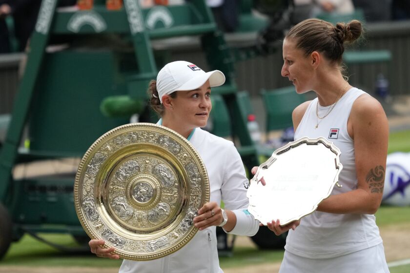 FILE - Australia's Ashleigh Barty, left, and Czech Republic's Karolina Pliskova stand with their trophies at the end of the women's singles final match on day twelve of the Wimbledon Tennis Championships in London, Saturday, July 10, 2021. Two-time Grand Slam finalist Karolina Pliskova is reuniting with coach Sascha Bajin ahead of the 2023 season. Pliskova posted on her website and her Twitter account on Tuesday, Dec. 6, 2022, about the move, which comes about six months after they stopped working together. (AP Photo/Alberto Pezzali, File)