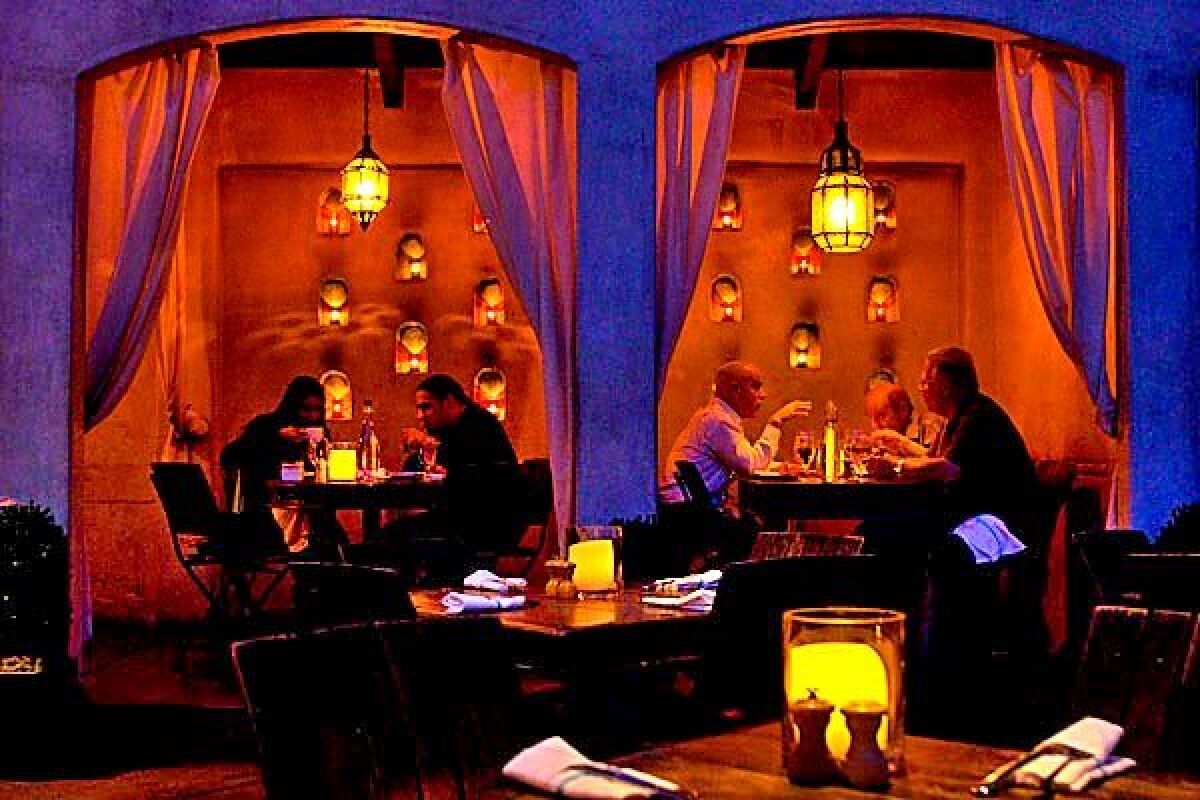 The atmospheric dining area at Firefly features two fireplaces and curtained cabanas.
