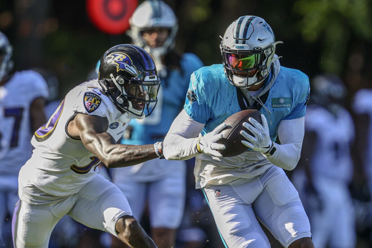 Carolina Panthers wide receiver D.J. Moore, right, runs after a catch against Baltimore Ravens cornerback Chris Westry during a joint practice hosted by Carolina at the NFL football team's training camp in Spartanburg, S.C., Wednesday, Aug. 18, 2021. (AP Photo/Nell Redmond)
