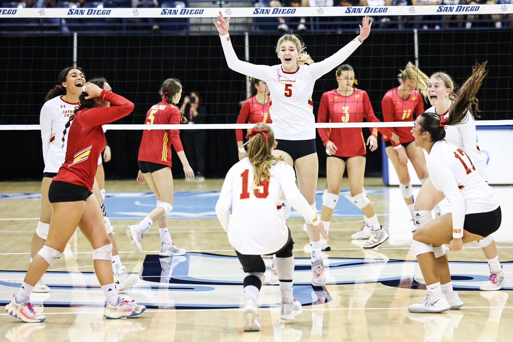 Cathedral Catholic's Jenna Hanes (5), center, and teammates celebrate