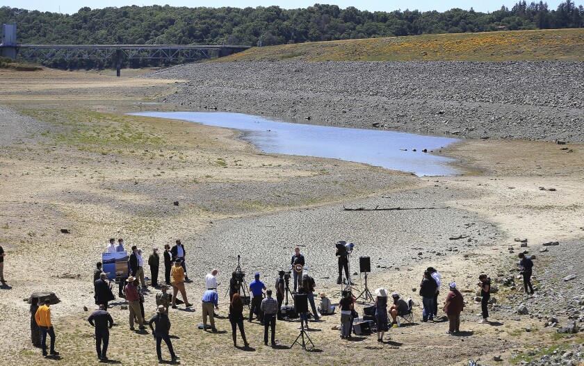 People stand in a parched lakebed
