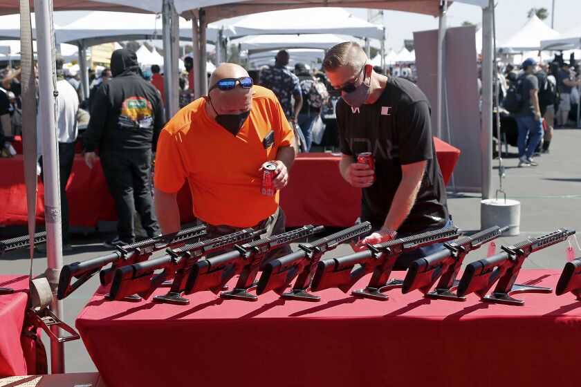 Gun enthusiasts check out sporting rifles during Crossroads of the West Gun Show on Saturday at the OC Fair & Event Center in Costa Mesa.