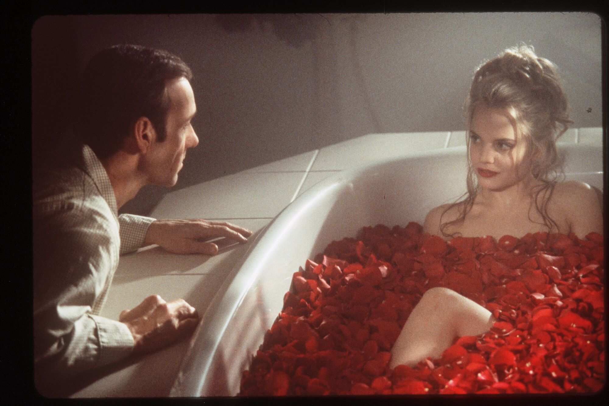 Kevin Spacey looks at Mena Suvari, in a tub full of roses, in "American Beauty."