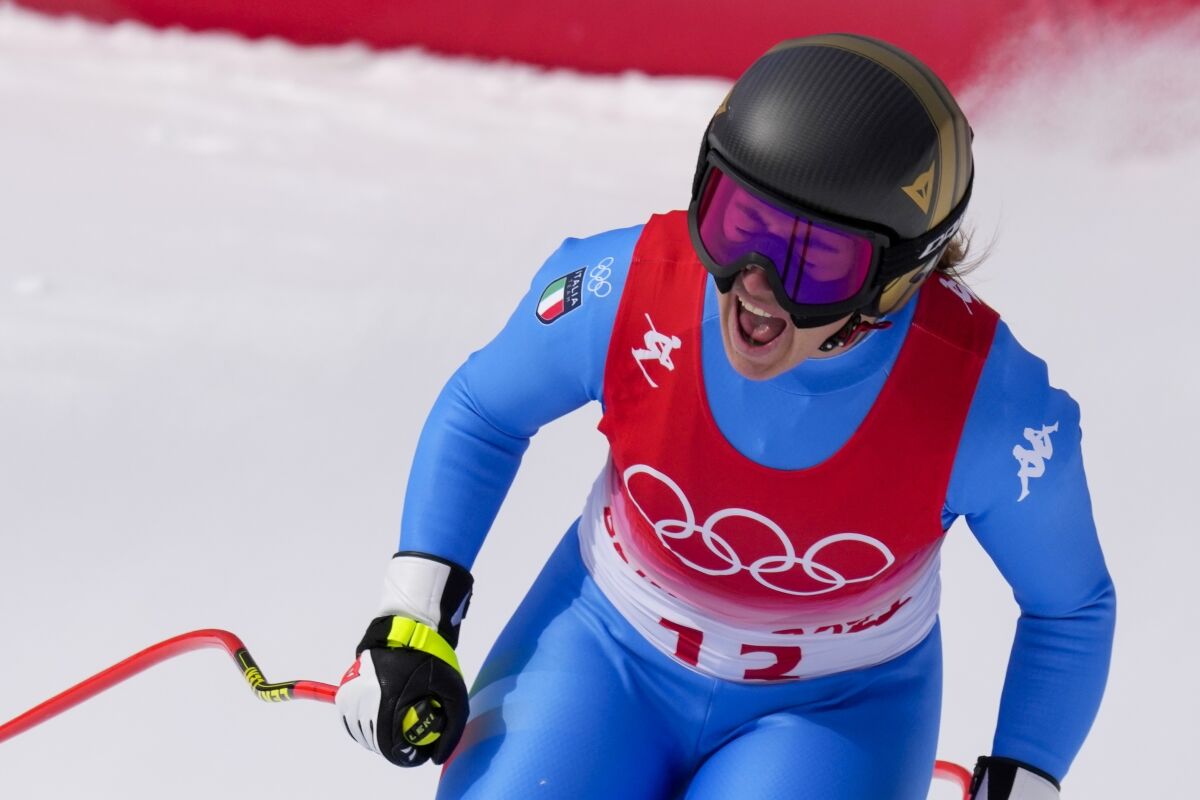 Sofia Goggia, of Italy, celebrates after finishing the women's downhill at the 2022 Winter Olympics, Tuesday, Feb. 15, 2022, in the Yanqing district of Beijing. (AP Photo/Luca Bruno)