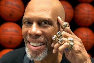 Lakers star Kareem Abdul-Jabbar poses with his championship rings.