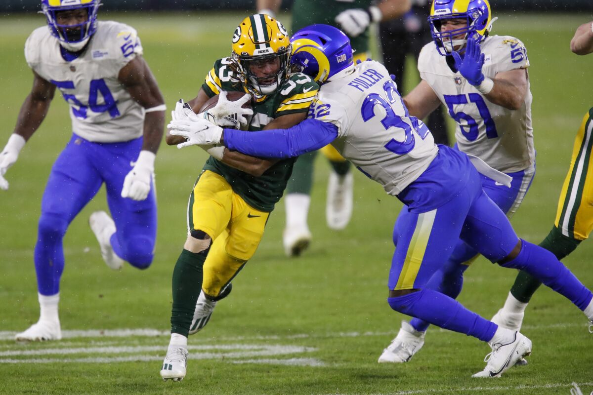 Green Bay Packers running back Aaron Jones is tackled by the Rams safety Jordan Fuller.