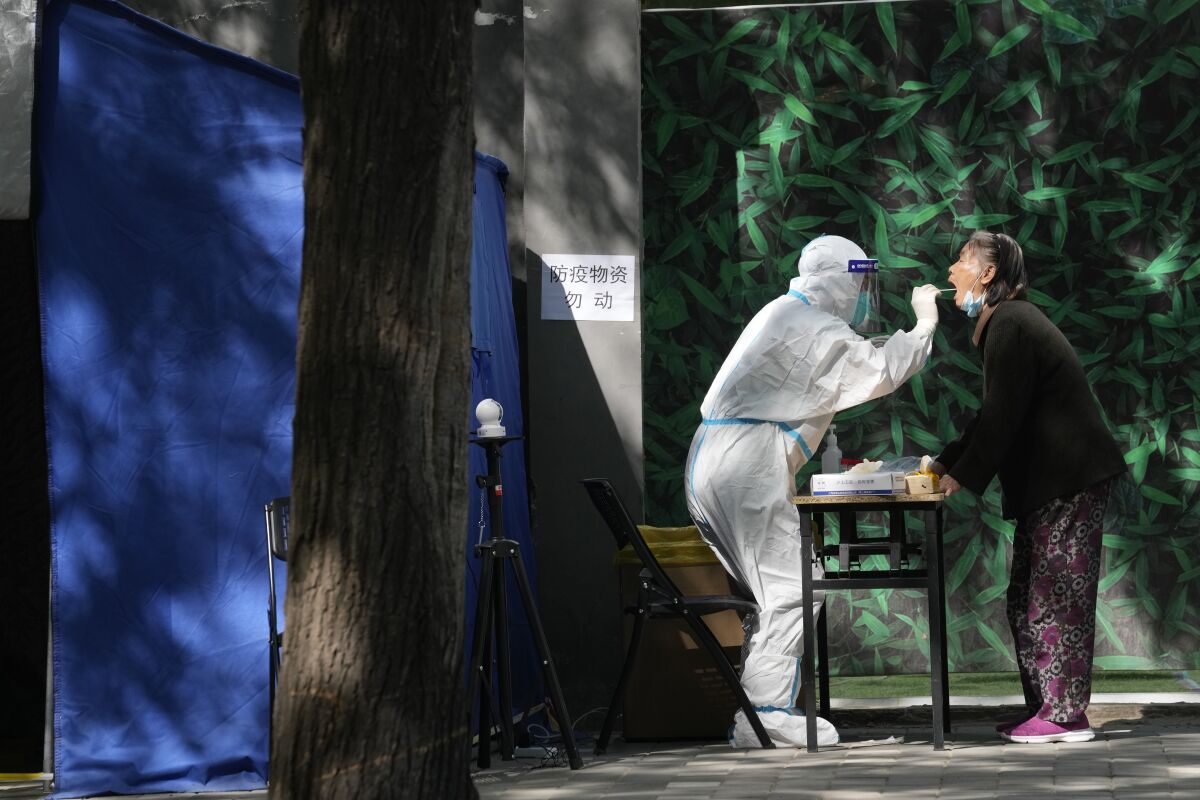 An elderly resident gets swabbed during a mass COVID-19 test on Tuesday, May 3, 2022, in Beijing. China has stuck to its strict "zero-COVID" approach that restricts travel, mass tests entire cities and sets up sprawling temporary facilities to try to isolate every infected person. (AP Photo/Ng Han Guan)