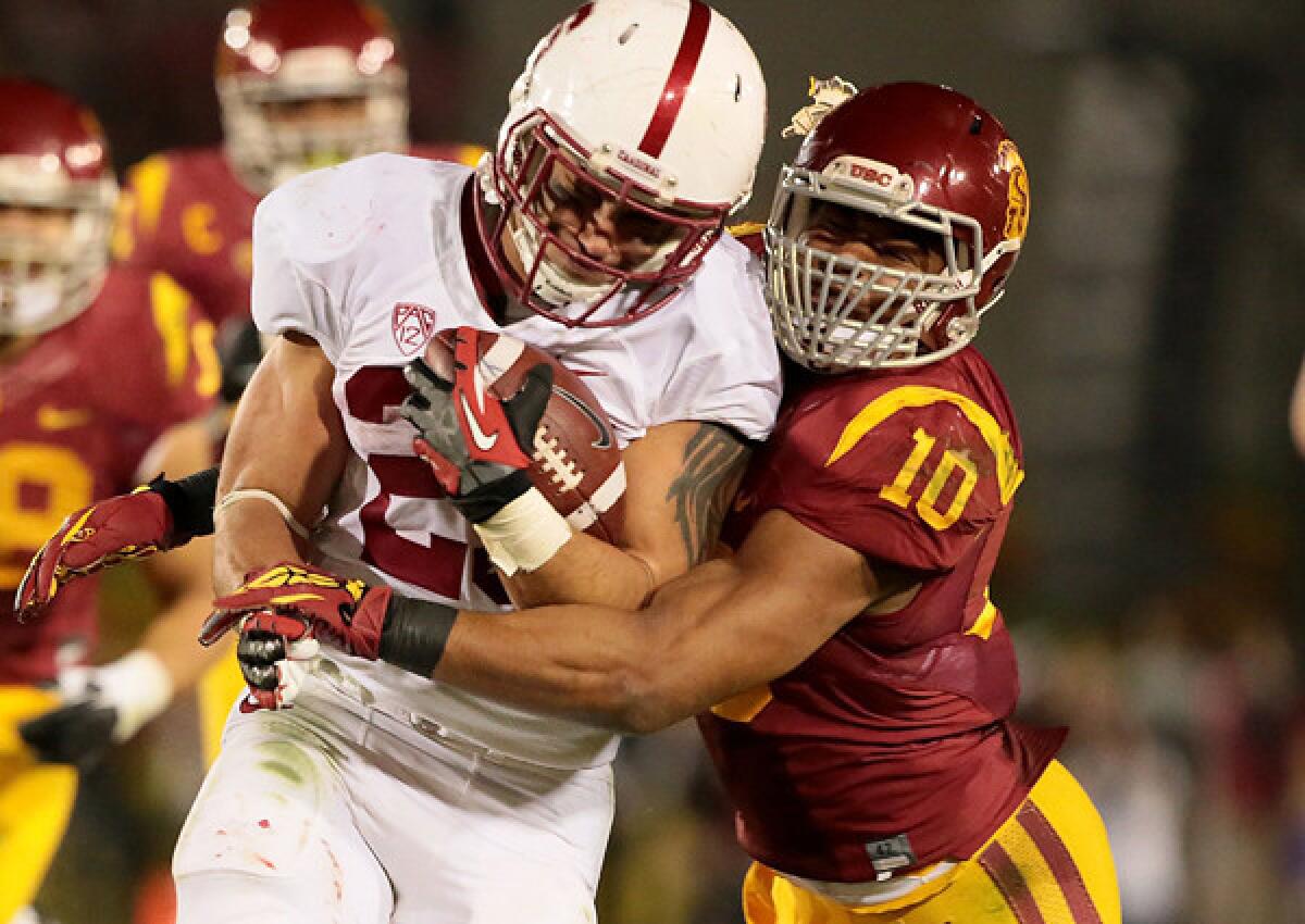 USC linebacker Hayes Pullard brings down Stanford running back Tyler Gaffney during their sold-out Pac-12 Conference game Saturday night at the Coliseum.