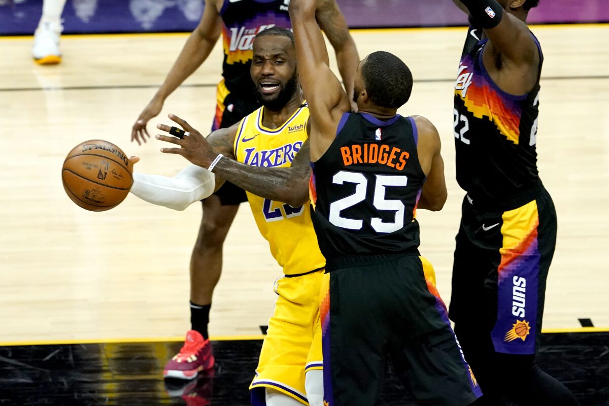 Los Angeles Lakers forward LeBron James passes around Phoenix Suns forward Mikal Bridges