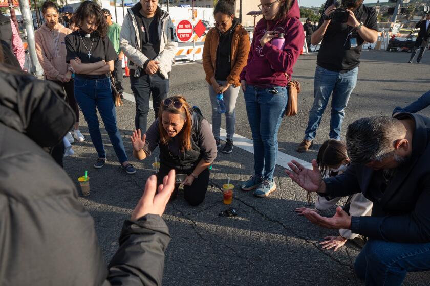 MONTEREY PARK, CA - JANUARY 22: A prayer circle forms at the corner of Garvey Avenue and Garfield Avenue on Sunday, Jan. 22, 2023 near Star Dance Studio where 10 people were killed and 10 injured in a mass shooting Saturday night. (Myung J. Chun / Los Angeles Times)