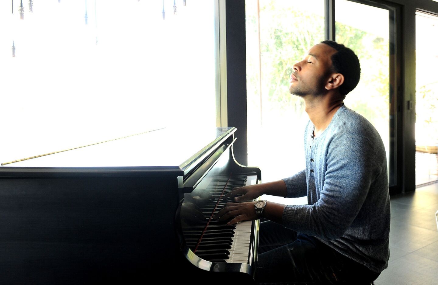 R&B singer John Legend plays the piano at his home in Los Angeles and will be coming out with a new album, "Love in the Future."