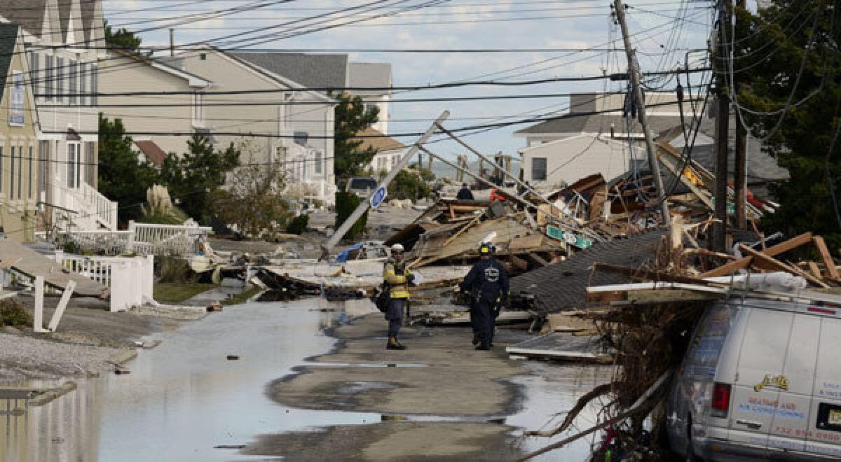 Emergency personnel in Seaside Heights, N.J., work on property and homes heavily damaged by Hurricane Sandy.