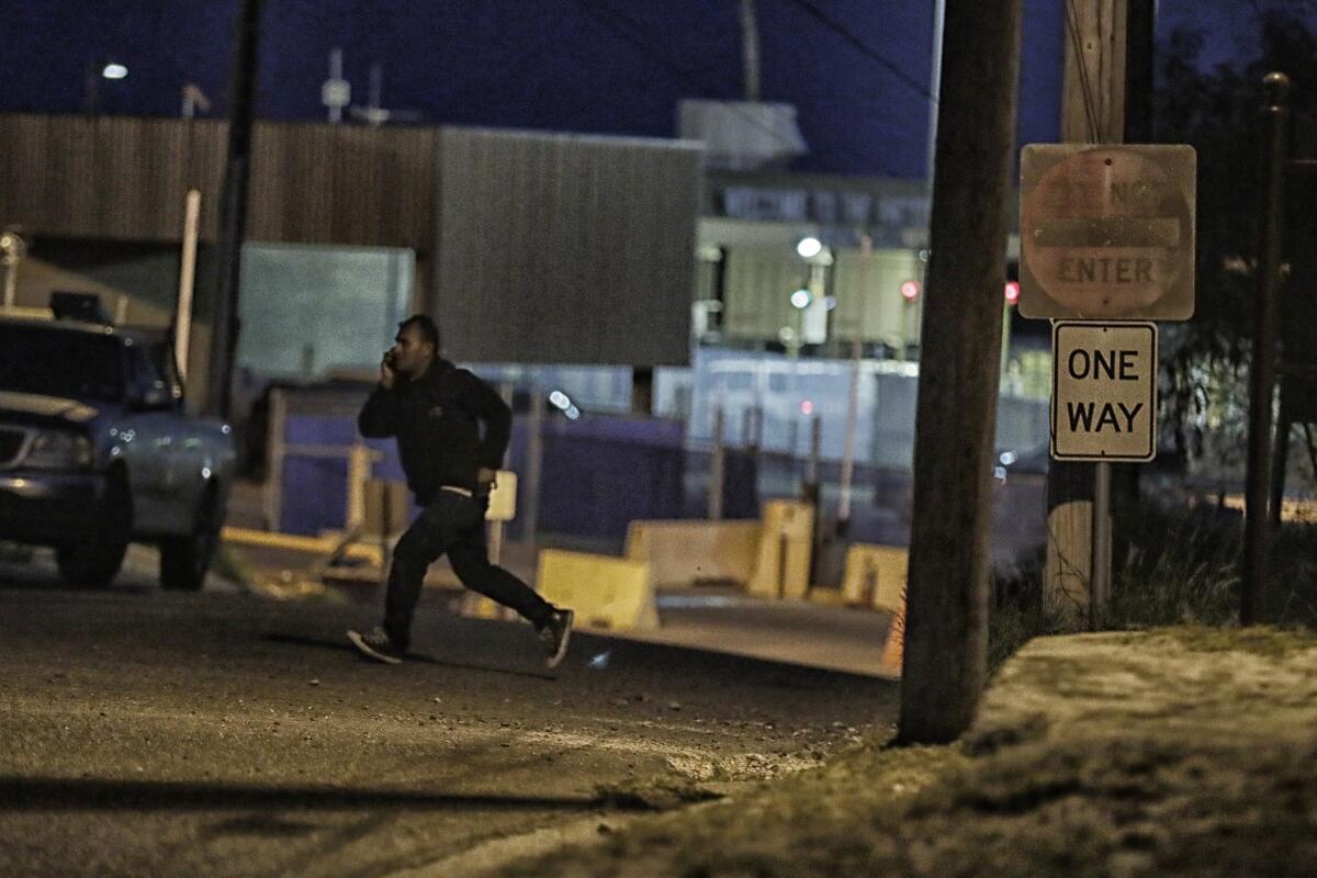 A border crosser hustles across Portscheller Street along Juarez Avenue in the shadow of the U.S. Customs border office in Roma, Texas.