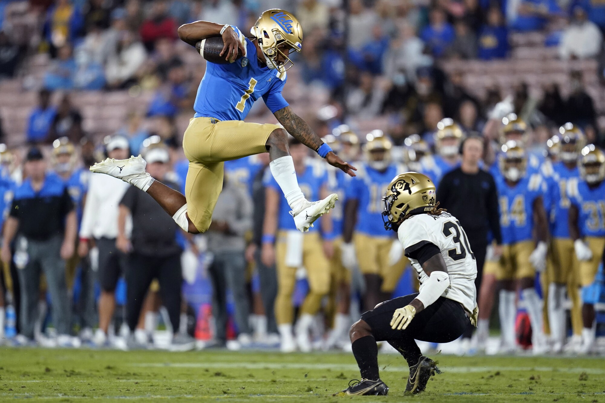 Le quart-arrière de l'UCLA Dorian Thompson-Robinson saute sur la sécurité du Colorado Curtis Appleton II.