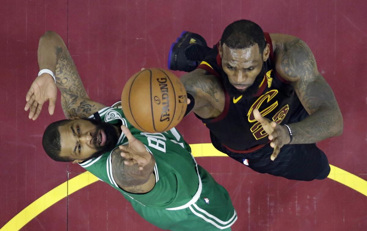 LeBron James, de los Cavaliers de Cleveland, salta hacia la cesta frente a Marcus Morris, de los Celtics de Boston, en el cuarto partido de la final de la Conferencia del Este, el lunes 21 de mayo de 2018 (AP Foto/Tony Dejak)