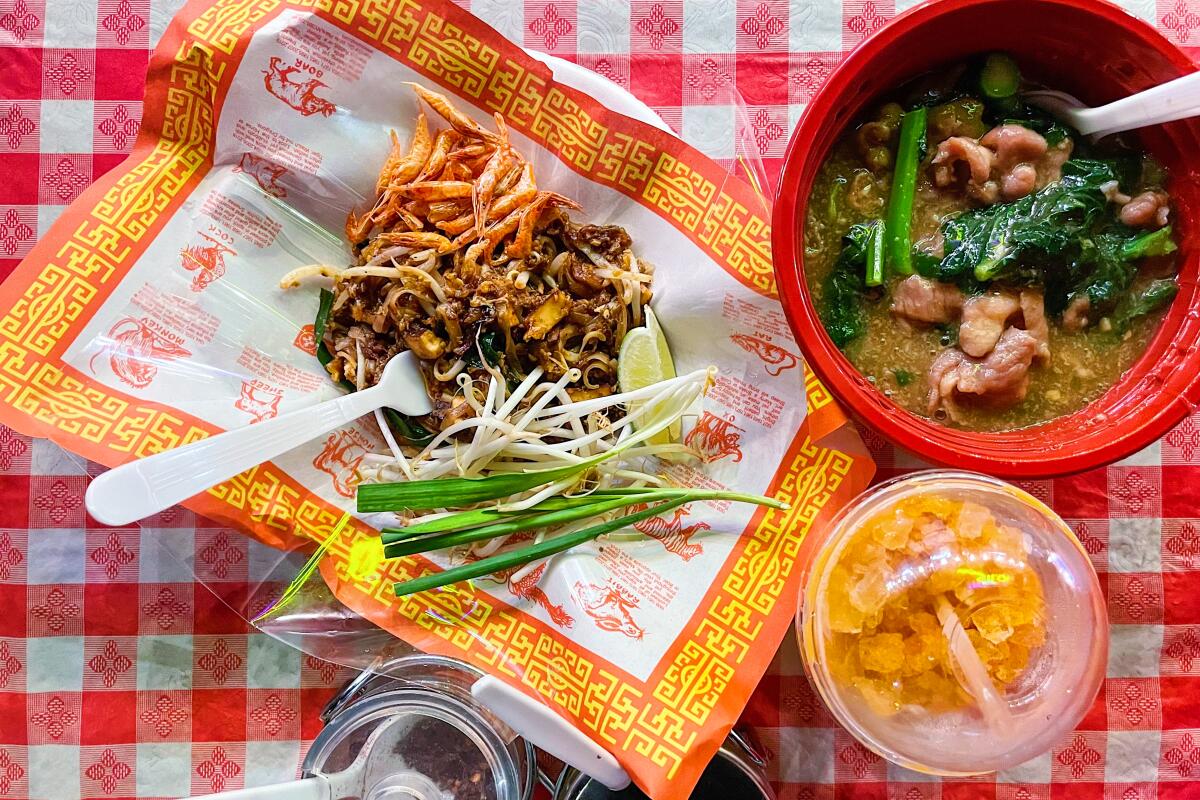 An overhead photo of Radna Silom's pad Thai and radna, served atop a red-and-white checkered tablecloth.