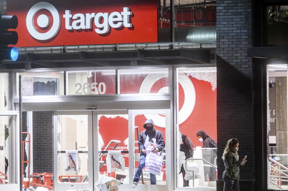 Un grupo de personas salen de una tienda saqueada de la cadena Target en Oakland, California, el sábado 30 de mayo de 2020, durante las protestas por la muerte de George Floyd, un afroestadounidense que se encontraba esposado al momento de morir a manos de la policía en Minneapolis.
