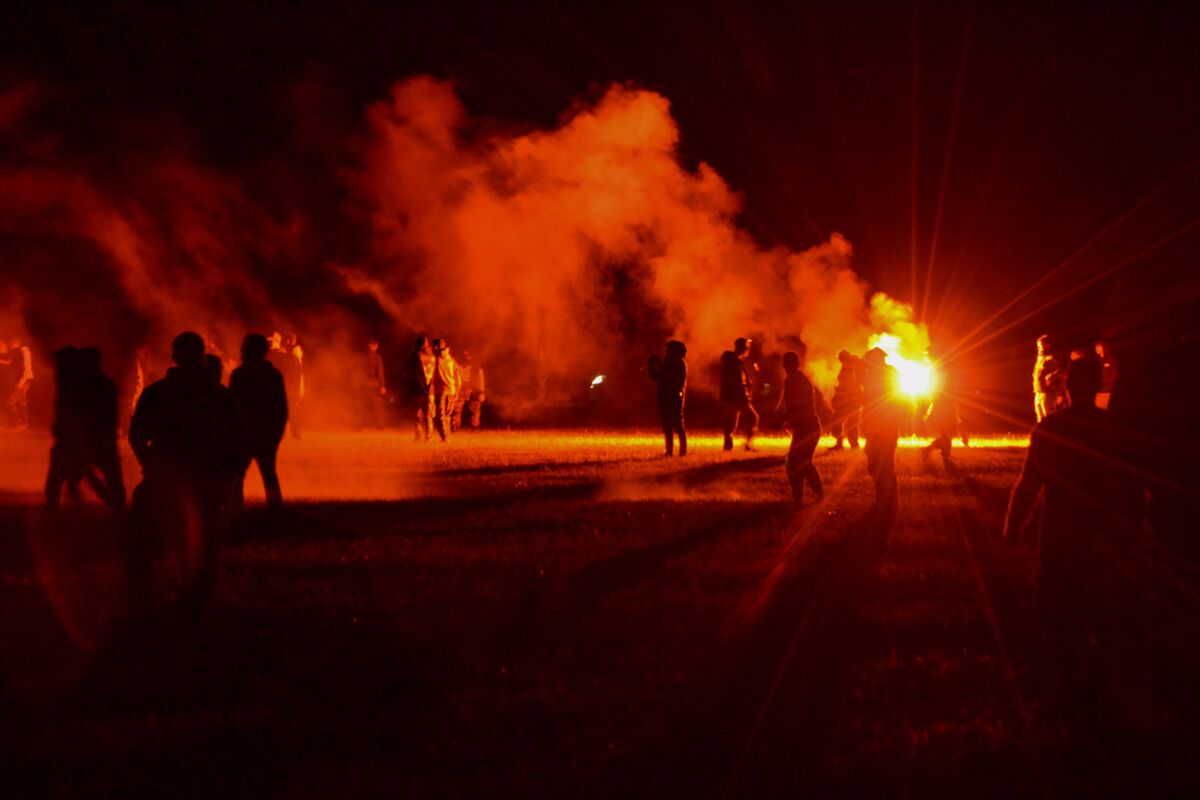 Partygoers on a field during clashes with police in western France on Friday.