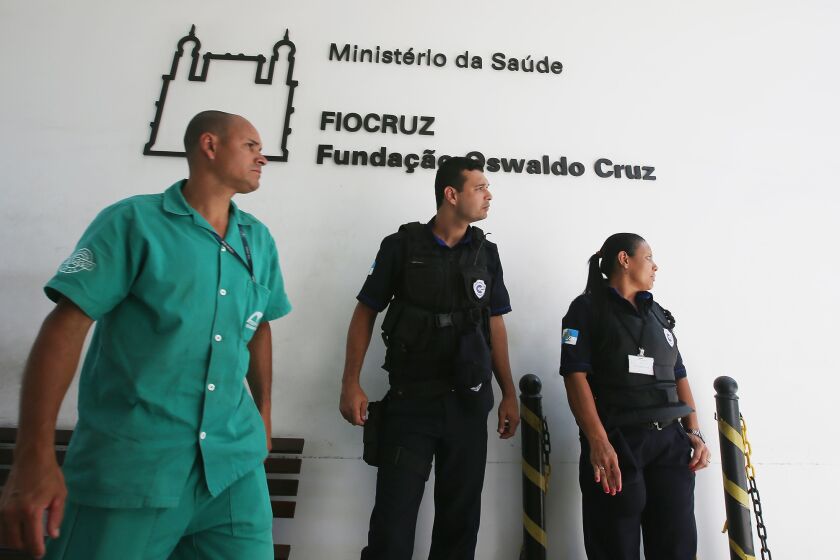 Staff and security personnel stand near an entrance to the National Institute for Infectious Diseases in Rio de Janeiro last week. A patient suspected of being infected with the Ebola virus has been cleared and released in Brazil.