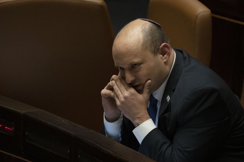 Israeli Prime Minister Naftali Bennett makes a call before voting on a law on the legal status of Jewish settlers in the occupied West Bank, during a session of the Knesset, Israel's parliament, in Jerusalem, Monday, June 6, 2022. (AP Photo/ Maya Alleruzzo)