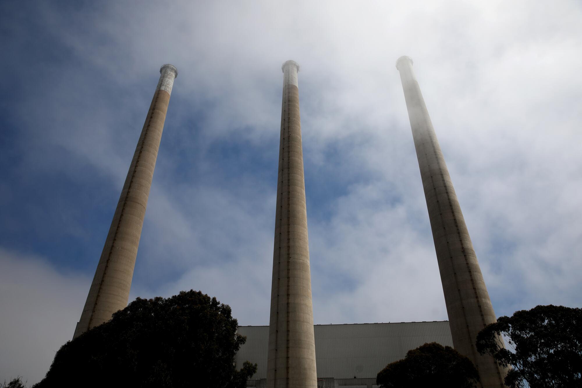Three smokestacks rise from a building