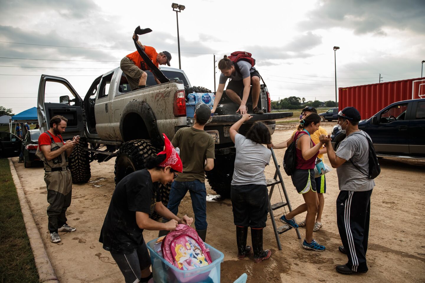 People hop off Chris Ginter's truck as he helps ferry residents around Katy, Texas.