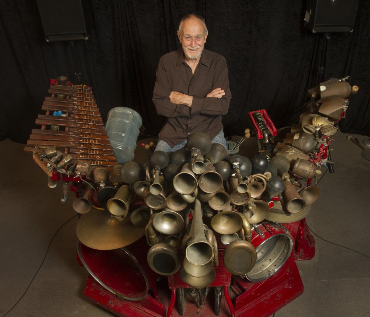 Artist Llyn Foulkes with "The Machine," a sculptural configuration of cow bells, drums, organ pipes, antique car horns and hoses, among other things.